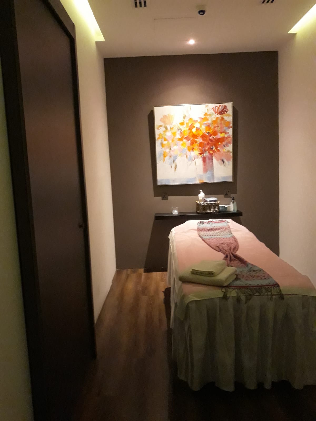 Photograph of massage therapy room with high massage bed